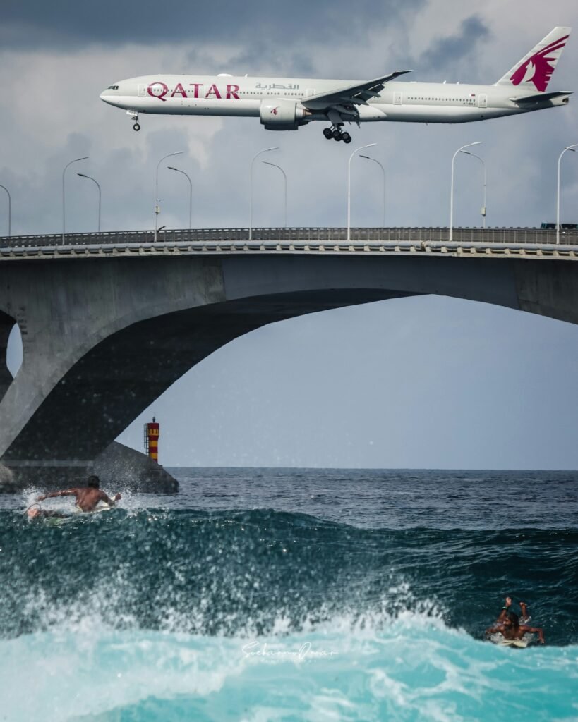 Aereo Qatar Airways volando sopra un ponte